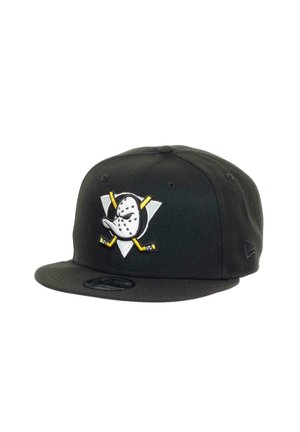 Black snapback cap featuring a hockey mask and crossed sticks design in white and yellow on a triangular emblem. Material is fabric with a flat brim.