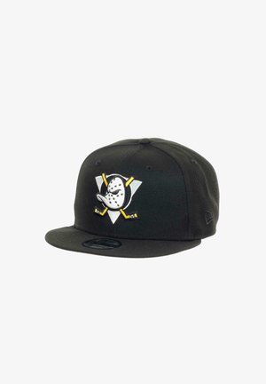 Black snapback cap featuring a hockey mask and crossed sticks design in white and yellow on a triangular emblem. Material is fabric with a flat brim.