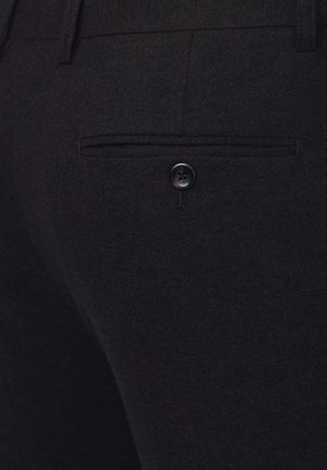 Ciemnoszare wełniane spodnie z tylną kieszenią z czarnym guzikiem. Tkanina ma teksturowane wykończenie, odpowiednie do ubrań formalnych lub półformalnych.