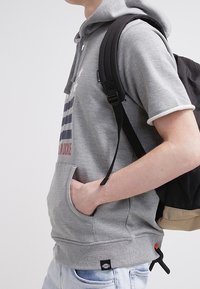 Sudadera gris con bolsillo frontal, mangas cortas y capucha ajustable, adornada con un diseño de bandera a rayas y acentos en las mangas en contraste.