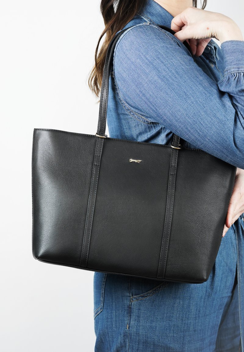 Zwarte leren tote bag met een gestructureerd ontwerp, twee lange handvatten en subtiele stiksels. Bevat een klein, minimalistisch logo aan de voorkant.