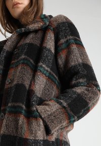 Brun, sort og grøn ternet uldfrakke med rundet krave, store knapper og sidelommer, lavet af blødt, struktureret stof.