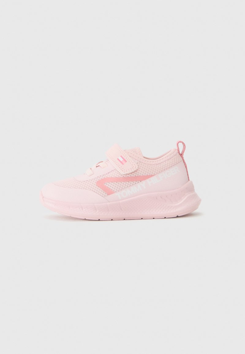 Zapatilla deportiva rosa con parte superior de malla, correa de velcro y suela de goma. Presenta detalles en blanco del logo y un diseño texturizado en el talón.