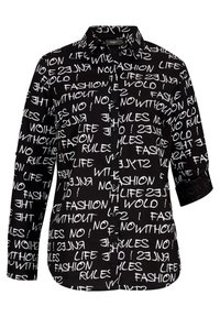 Chemise noire à boutons avec un motif de texte blanc contenant des phrases. Manches longues retroussées aux poignets, col classique et texture de tissu lisse.