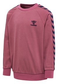 Różowa bluza z okrągłym dekoltem, prążkowanymi mankietami i dołem oraz kontrastowymi bocznymi akcentami w wzór chevron w granatowym kolorze. Logo Hummel wyszyte na piersi.