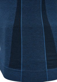 Stickad plagg i djupblått med texturerade och släta paneler. Har kontrasterande randiga sektioner och en ribbad nederkant för detalj.