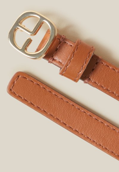 Cinturón de cuero marrón claro con hebilla circular de tonalidad dorada que presenta un diseño entrelazado. Textura suave con detalle de costura visible a lo largo de la correa.