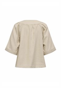 Haut beige clair à manches courtes avec col, détails froncés au dos, coupe décontractée et texture lisse.