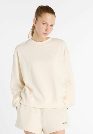 Cream-colored sweatshirt made of soft fabric with a crew neckline and a small white logo on the chest. Features a relaxed fit and ribbed cuffs.