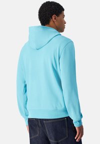 Sudadera con capucha en azul claro, presenta una capucha en la parte posterior, mangas largas y puños acanalados. Tejido suave con una textura lisa.