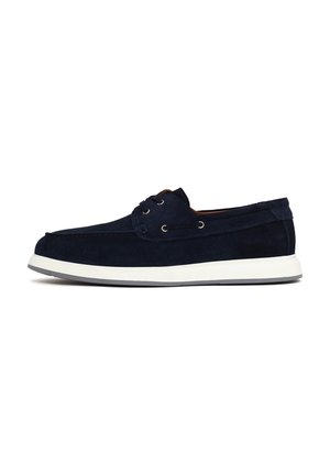 Navy blue suede boat shoe with white rubber sole, lace-up front, and metal eyelets, designed for casual wear.