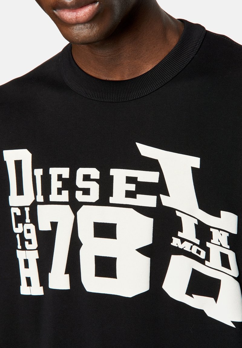 Felpa nera con grande testo grafico bianco in vari font e stili, compresi "Diesel" e "78", su un tessuto testurizzato.