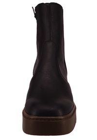 Bota de cuero negro hasta el tobillo con puntera redonda, cremallera lateral y suela gruesa marrón. Textura suave y diseño minimalista.