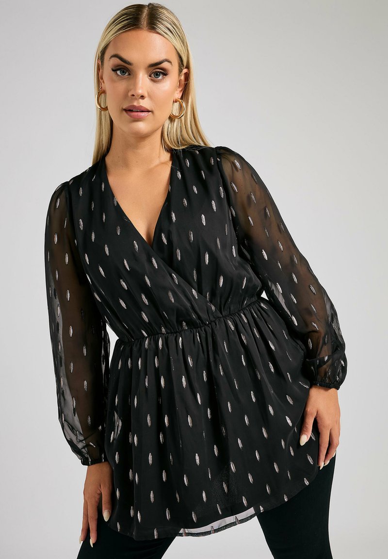 Blusa nera con maniche lunghe trasparenti, vita cinte e scollo a V. Presenta motivi argentati a forma di foglia su tutto il tessuto. Texture morbida.
