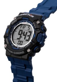 Orologio digitale con cinturino in gomma blu, cassa in plastica nera, grande display LCD che mostra l'ora e il giorno, e pulsanti per le funzioni. Waterproof fino a 100m.