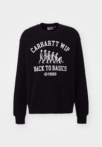 Felpa nera Carhartt WIP con grafica di evoluzione dello scheletro bianca e testo "Carhartt WIP Back to Basics ©1989" sul davanti.