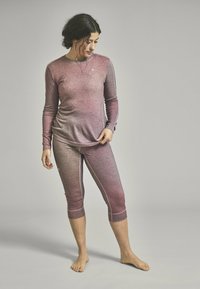 Long-sleeve gradient top and cropped leggings in shades of pink. Stretchy fabric with subtle sheen and contrasting stitching detail.