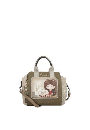 Piccola borsa a mano verde oliva e beige con illustrazione di una ragazza dei cartoni animati, ciondoli decorativi e il nome del marchio "Anekke" sulla parte anteriore.