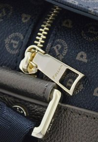 Borsa in pelle nera con zip in metallo dorato, caratterizzata da un'etichetta del brand. Il tirazip ha una forma rettangolare con dettagli incisi.