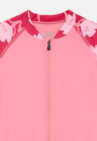 Rosa Rashguard mit einem mittellangen Reißverschluss, der ein florales Muster in den Farben Rosa und Rot an den Schultern und am Hals aufweist.