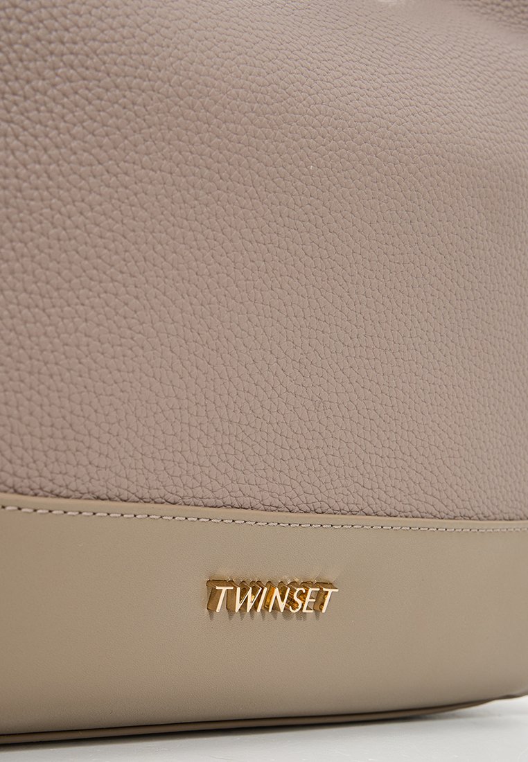 Beige strukturerad läderväska med en slät nederdel och en guld "TWINSET" logotavla. Har kontrasterande sömmar längs botten.