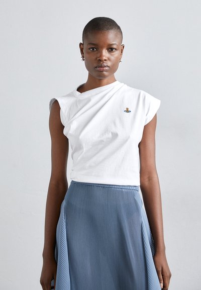 T-shirt blanc à manches courtes avec un design asymétrique et un logo brodé, associé à une jupe plissée bleu clair. Texture lisse.