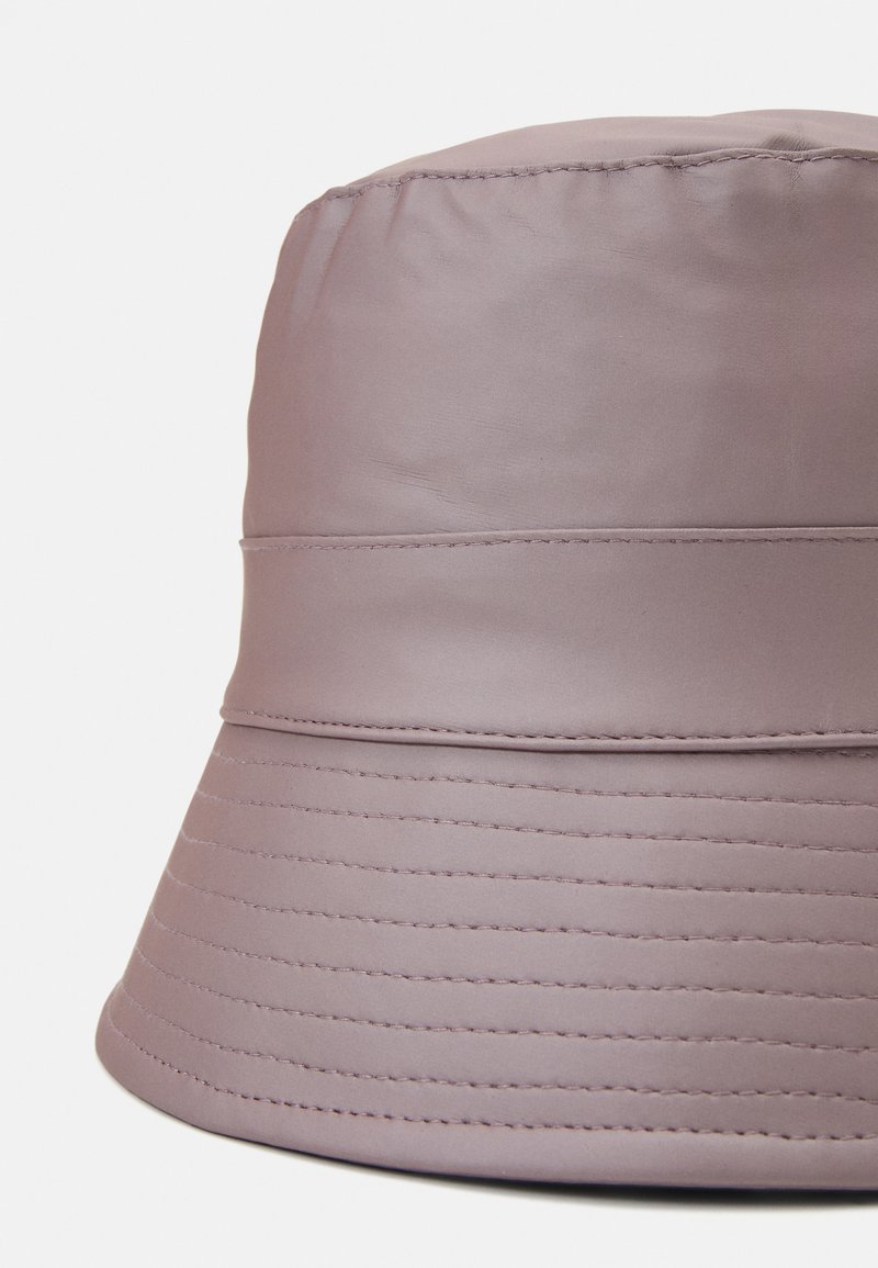 Cappello a secchiello realizzato in tessuto liscio di colore viola chiaro, caratterizzato da una forma cilindrica, cuciture orizzontali e una visiera larga per una maggiore copertura.