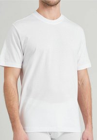 T-shirt blanc à manches courtes en coton, avec un col rond et une coupe décontractée, offrant une texture lisse et sans motifs ni graphiques visibles.
