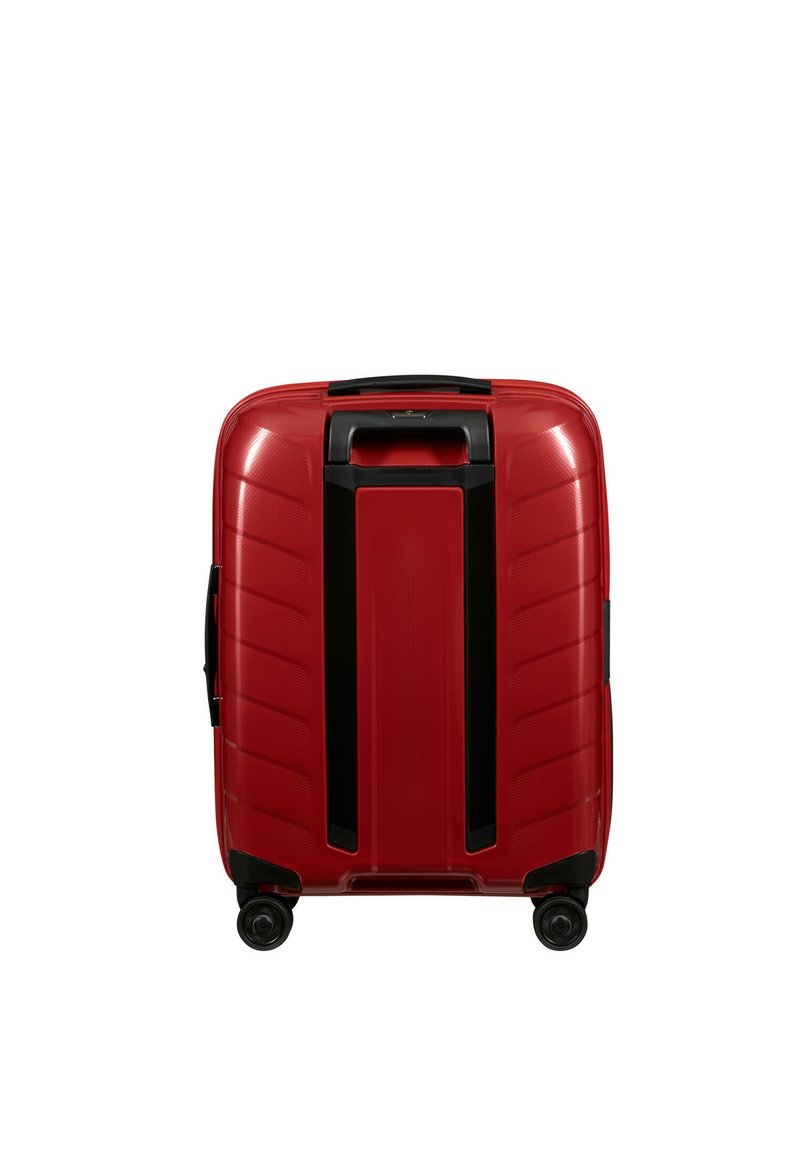 Maleta dura roja con superficie texturizada, acentos negros, mango retráctil y cuatro ruedas giratorias para mayor movilidad.