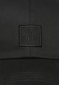 Zwarte pet met een gestructureerde stof en een gestikt vierkant patch waarop de initialen "MOP" in zwarte draad zijn weergegeven.