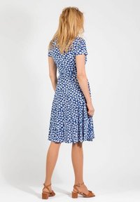 Niebieska sukienka w kwiaty z krótkimi rękawami, dopasowanym korpusem i rozkloszowanym dołem. Wykonana z lekkiego materiału z białym wzorem kwiatowym.