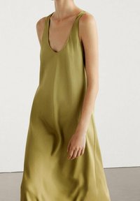 Olivengrünes ärmelloses Kleid mit tiefem V-Ausschnitt, aus glattem Stoff gefertigt, mit fließender Silhouette und minimalistischem Design.