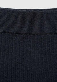 Pletená tmavě modrá tkanina s žebrovanou strukturou a hladkým povrchem; má jednoduchý, konzistentní vzor bez viditelných ozdob.