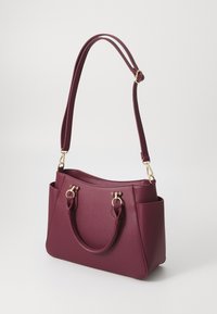 Borsa bordeaux con una finitura a trama, doppi manici, dettagli in metallo dorato e tasche laterali per una maggiore funzionalità.