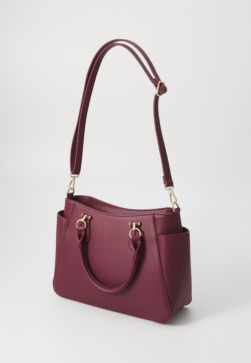 Bolso burdeos con acabado texturizado, doble asa para el hombro, detalles en hardware dorado y bolsillos laterales para mayor funcionalidad.