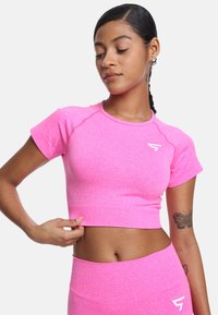 Kratka ružičasta atletska majica s ravnim izrezom i kratkim rukavima. Ima teksturiranu tkaninu i bijeli logo na prsima.