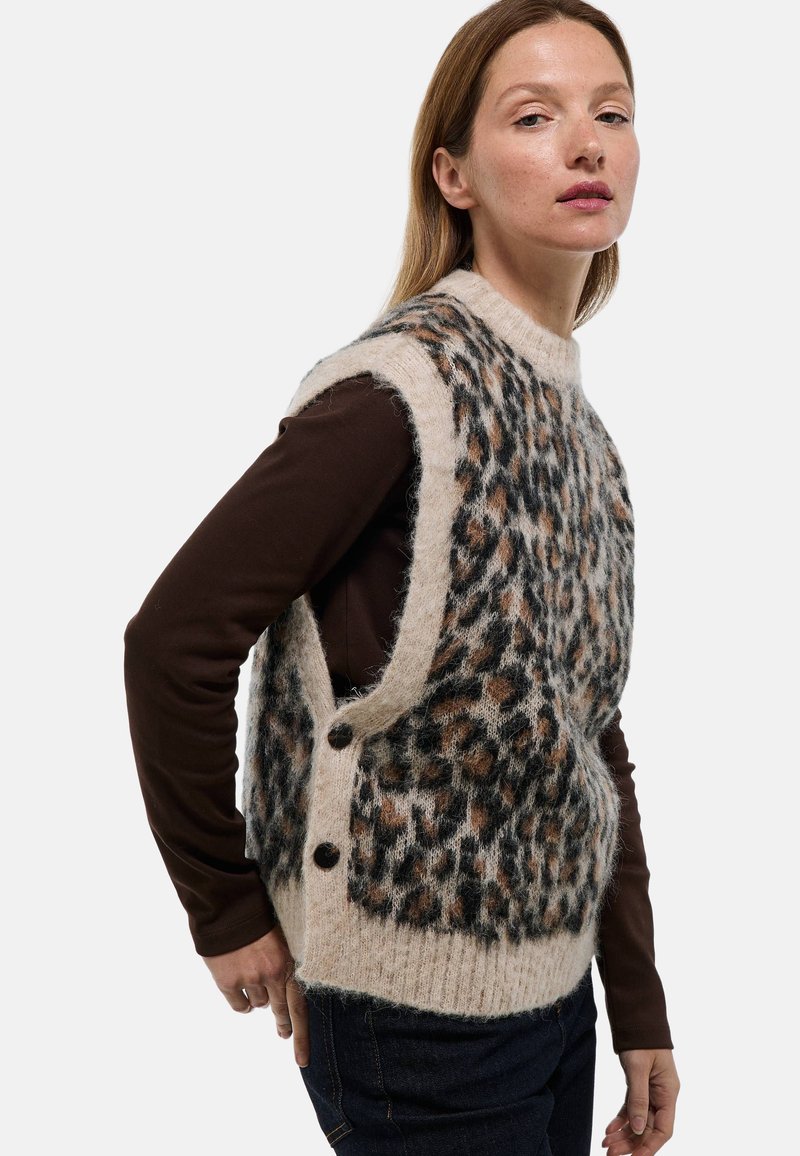 Gilet en tricot avec un motif léopard en tan, noir et marron, avec une texture douce, un design sans manches et des accents de boutons sur le côté.