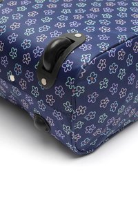 Navy roller bag with colorful floral pattern. Features a smooth black wheel and metallic accents. Textured fabric surface with a structured shape.