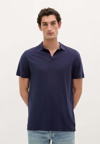 Marineblå kortærmet polo med klassisk krave, lavet af blødt stof, med lige pasform og minimale syninger.