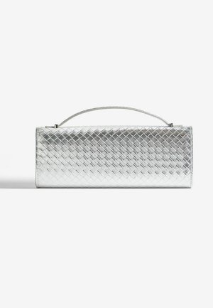 Borsa a mano argentata con design intrecciato e manico corto, posizionata su uno sfondo semplice.
