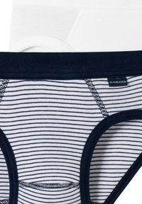 Weiß und marineblaue gestreifte Unterwäsche mit elastischen Bündchen, ausgestattet mit einem kleinen Markenetikett und kontrastierenden Nähten.