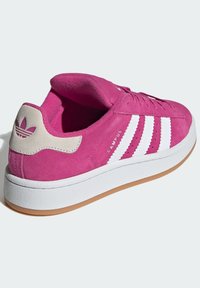 Roze zamšaste tenisice s tri bijele pruge, kremasto-smešim tabanom i teksturiranom gumenom potplatu sa smešim vanjskim slojem. Elegantni dizajnerski detalji.