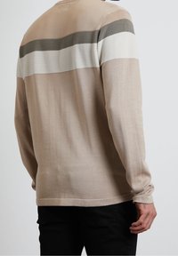 Beige long-sleeve sweater with textured horizontal stripes in olive green and white, featuring a relaxed fit and straight hem.