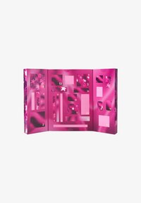 Calendrier de l'Avent rose avec divers compartiments, doté d'une finition brillante, de motifs d'étoiles et de fenêtres numérotées pour chaque jour.