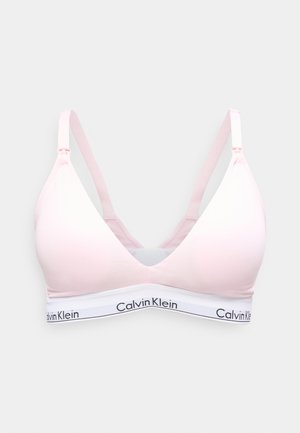 Bralette sans fil rose clair avec bretelles réglables et bande blanche portant le logo Calvin Klein noir.
