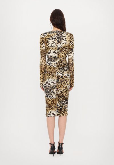 Leopard print midi dress in stretchy fabric, featuring long sleeves, a fitted silhouette, and a back zipper closure. Black high-heeled shoes.