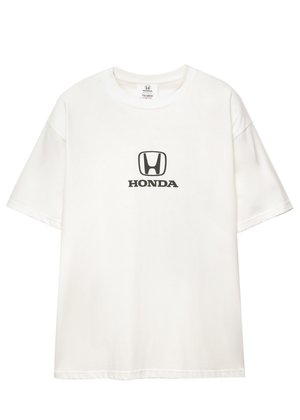 Valkoinen lyhythihainen T-paita, jossa on musta Honda-logo ja teksti keskitettynä rinnassa, esitettynä yksinkertaista taustaa vasten.