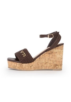 Sandalo con zeppa in pelle intrecciata marrone con plateau in sughero, cinturino alla caviglia e logo dorato "V73" sulla fascia frontale.