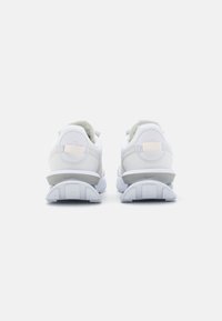 Vita idrottsskor i vitt med en slät syntetisk ovandel, rundad häldesign och en texturerad gummisula med synliga dämpningselement.