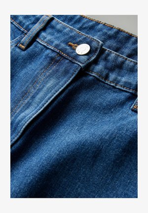 Dżinsy w niebieskim odcieniu, z zapięciem na srebrny guzik i widocznymi detalami przeszyć. Miękka tekstura i klasyczny design z pięcioma kieszeniami.